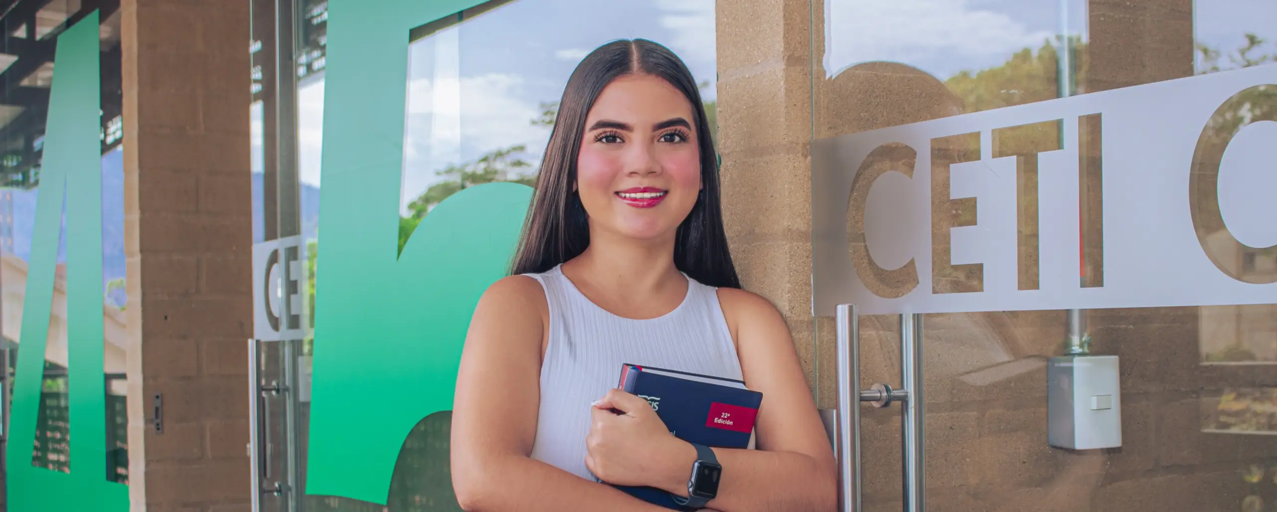 Estudiante apoyada en las puertas del Centro de Emprendimiento e Innovación CETI del TdeA