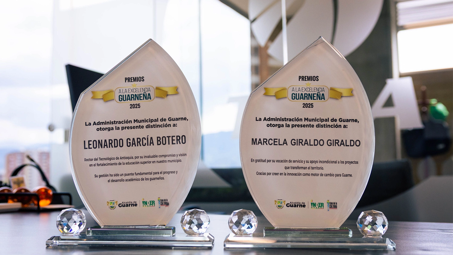 Los trofeos con los que fueron reconocidos el rector del TdeA, Leonardo García Botero y la secretaria General, Marcela Giraldo Girado.