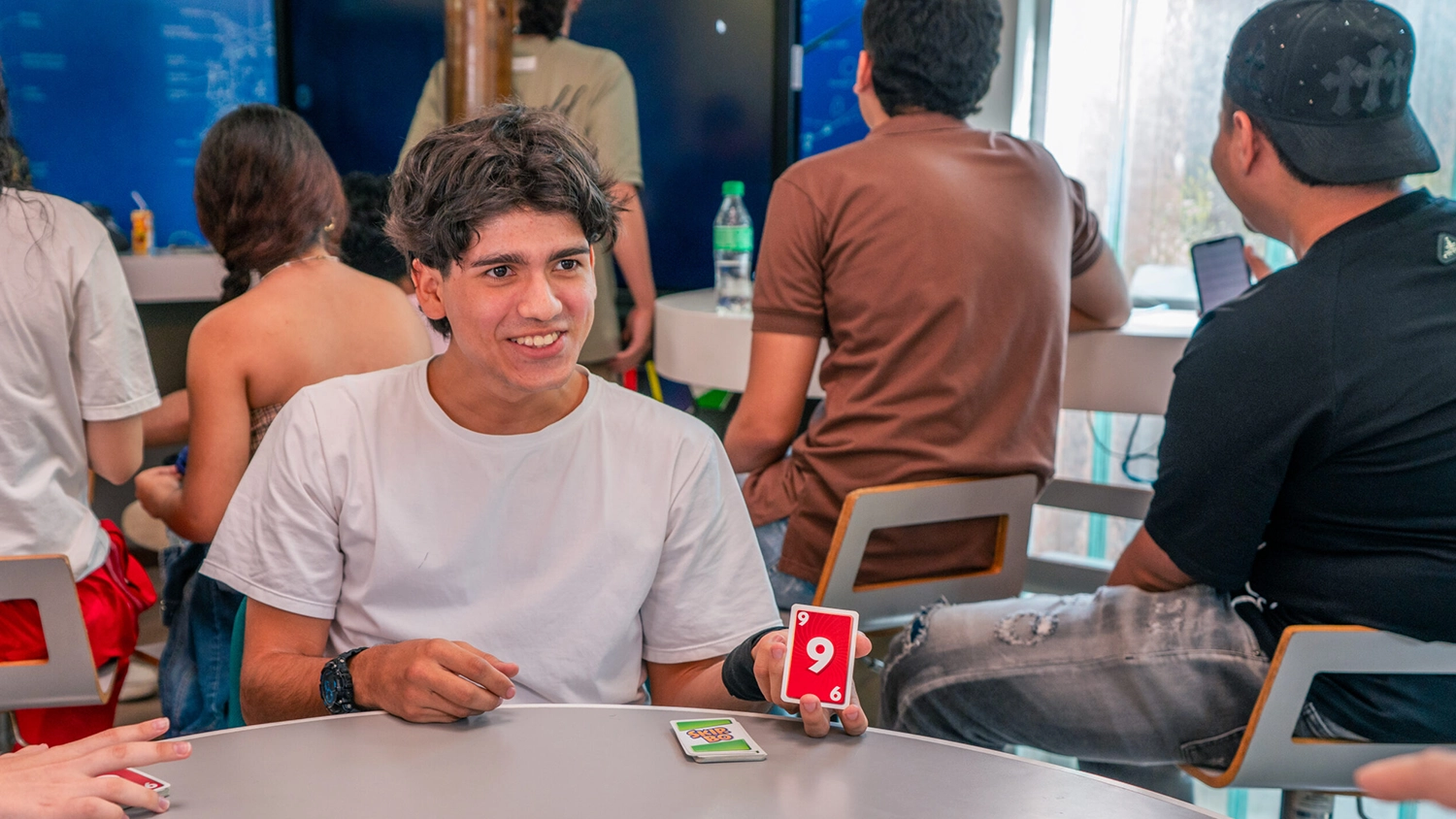 Estudiante mostrando su carta #9 en el juego Skip Bo.
