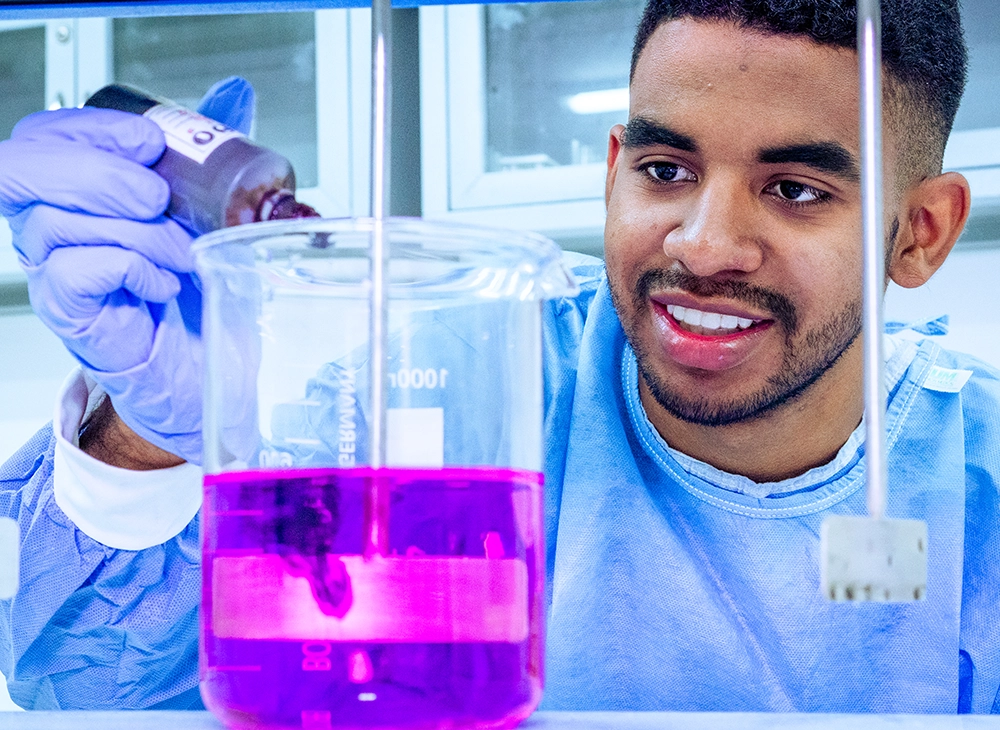 Estudiante haciendo una mezcla en el laboratorio de química.