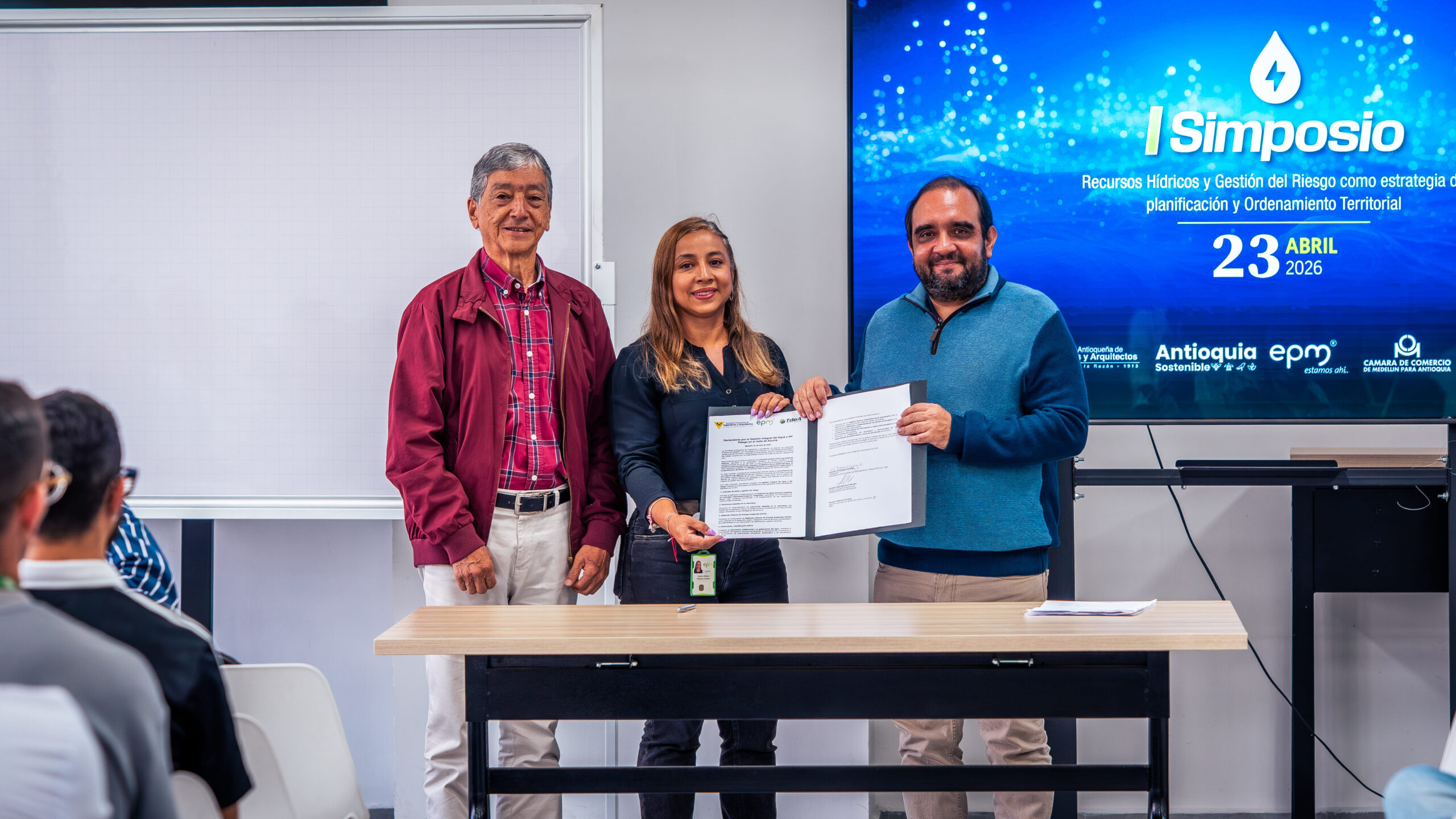Gerardo Domínguez Giraldo, presidente de la SAI, Andrés Felipe Montoya Rendón, decano de la Facultad de Ingeniería, y Marcela Ruiz Saldarriaga, secretaria de Medio Ambiente de Medellín, posan con un reconocimiento.